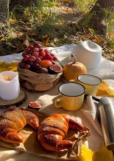 a table topped with croissants covered in powdered sugar next to fruit