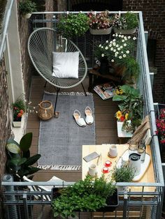 small balcony with plants and potted plants on the floor, including an iron chair