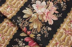 close up view of the fabric with flowers and leaves on black, red, yellow and pink colors