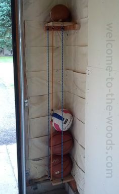 a wall mounted shelf filled with baseballs next to a door