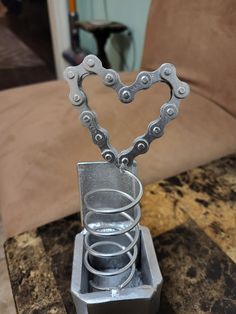 a heart shaped metal object sitting on top of a table