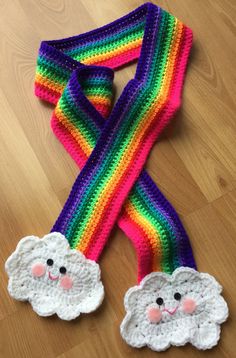 a crocheted scarf with two sheeps on it and a rainbow colored strip