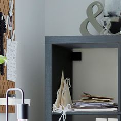 a shelf with papers and other items on it in a room next to a wall