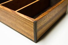 a close up of a wooden box on a white surface with no one around it