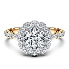 a yellow and white gold engagement ring with an intricate flower design on the center, surrounded by round brilliant diamonds