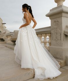 a woman in a wedding dress standing on some steps