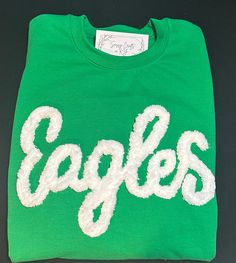 Show your school spirit in this cute sweatshirt. Comfort, casual and loose fitting, made on 50/50 cotton/poly blend shirts.  Embroidered chenille yarn, Eagles sweatshirt.  Show your school spirit in this cute sweatshirt. Comfort, casual and loose fitting, made on 80/20 cotton/poly blend shirts.  Please message us if you have a custom color request and we will create a separate listing for custom requests.  You can follow us at the below link for chances to win giveaways and to see all of our latest creations.  https://www.facebook.com/groups/710060383256657/?ref=share&mibextid=S66gvF You can follow us at the below link for chances to win giveaways and to see all of our latest creations. Pre-shrunk Crew Neck Sweatshirt For School Spirit, White Cotton Varsity Sweater, Varsity Cotton Sweatshirt For Fall, College Cotton Sweater With Embroidered Graphics, Cotton College Sweater With Embroidered Graphics, College Sports Season Tops With Letter Embroidery, Winter Cotton Sweatshirt Pre-shrunk, Winter Cotton Sweatshirt, Pre-shrunk, Winter Cotton Pre-shrunk Sweatshirt