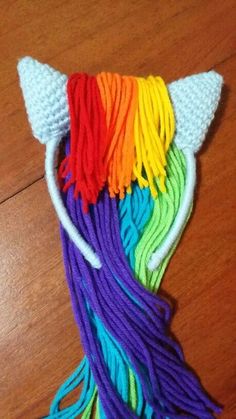 a close up of a piece of yarn on a wooden floor with an animal's head