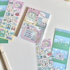 three notebooks with various stickers on them