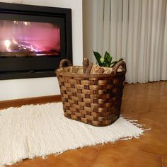 a basket sitting on the floor in front of a fireplace