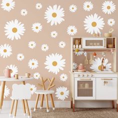 a child's playroom with white and yellow flowers on the wall, wooden table and chairs