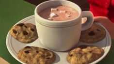 a cup of hot chocolate and cookies on a plate