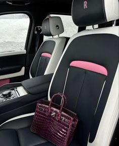 the interior of a car with black and white leather seats, pink trimmings