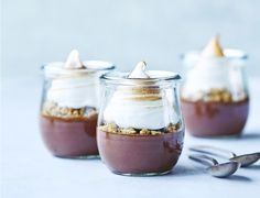 three desserts in small glass jars with spoons