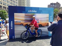 a man riding a bike next to a billboard