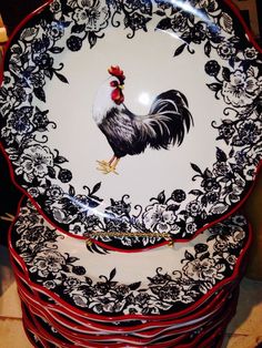 a stack of black and white plates with roosters on them