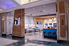 the inside of a nail salon with blue stools