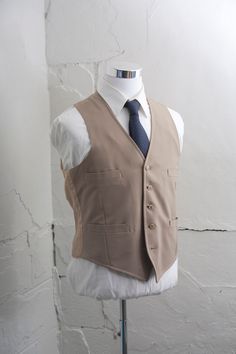 "This vintage vest is a solid khaki color. It has 5 buttons, 4 pockets, and no adjustable back. The wrinkles will release nicely with a good steaming or dry cleaning. NOTE: There is some staining on the back of the vest it is pictured.  Size:  * Chest: 42\" * Length: 22.5\" {measured on the back}  All measurements are taken with garments lying flat. Check out our Additional Policies & FAQ section for detailed sizing information: https://www.etsy.com/shop/BrightWall/policy?ref=shopinfo_policies Khaki Suit, Formal Vest, Custom Made Suits, Mens Suit Vest, Fashion Suits For Men, Vintage Vest, Men's Suit, Suit Vest, Khaki Color