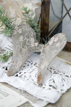 an old pair of shoes sitting on top of a lace doily