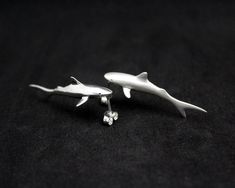 Sharks, such beautiful, strong creatures. They represent strength, intuition, dominance, the deep blue ocean and its mysteries. If you are a fan of the jaws this beautiful shark will fit in your taste like a ... shark -----Details---- A shark earrings pair from solid sterling silver hand carved using the lost wax method. Size: 40mm/1.57 inch long, 13mm/0,51 width, 8mm/0.31 high. Check out more sea creatures here https://www.etsy.com/shop/jewelsculpts?section_id=13464974&ref=shopsection_leftn Shark Rings Jewelry, Shark Teeth Earrings, Shark Earings, Shark Accessories, Hammerhead Shark Necklace, Sci Fi Jewelry, Pisces Jewelry, Shark Jewelry, Shark Stuff