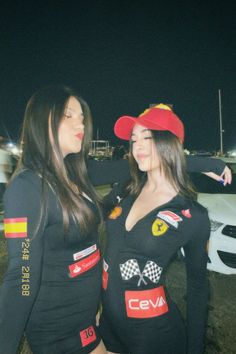 two women dressed in racing outfits standing next to each other