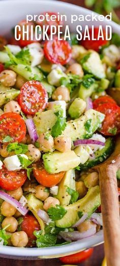 a salad with chickpea, tomatoes and cucumber in a white bowl