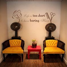 two yellow chairs sitting next to each other in front of a wall with writing on it