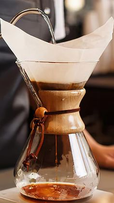 a coffee pot filled with liquid on top of a table