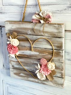 a wooden sign with flowers hanging from it