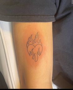 a person with a tattoo on their arm that has flames in the shape of a heart