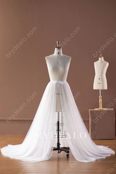 a white wedding dress on display in front of mannequins and dummyes