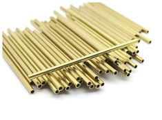 gold colored metal rods are stacked on top of each other, with one end missing