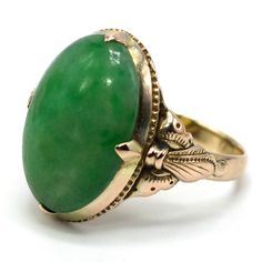 This lovely ring—probably made in the 1920s—is made of gold fill and is replete with elegantly simple Arts & Crafts design elements. The central stone is an oval piece of verdant nephrite jade. Metal: Gold Fill Main Stone: 1 Oval Cut Cabochon Jade (nephrite, 16.11 x 11.36 mm) Ring Size: 6.0 (can be sized) Heirloom Green Emerald Oval Cabochon Ring, Heirloom Green Oval Cabochon Emerald Ring, Heirloom Jade Jewelry In Green, Heirloom Green Oval Cabochon Jewelry, Heirloom Green Oval Cabochon Rings, Heirloom Green Jade Jewelry, Oval Jade Rings Hallmarked, Green Oval Heirloom Jewelry, Heirloom Oval Green Jewelry