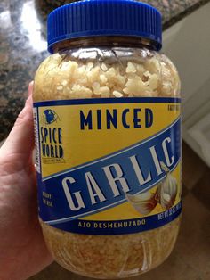 someone holding a jar of garlic rice in their left hand and the lid is open