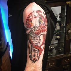 a man with a tattoo on his arm has a red snake wrapped around the cross