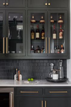 a kitchen with black cabinets and gold trimmings on the glass front cabinet doors