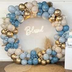 a blue and gold balloon wreath with the word, blessed on it in front of a white wall