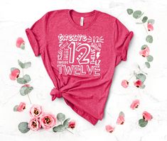 a pink shirt with the words grandma bear on it next to some flowers and leaves