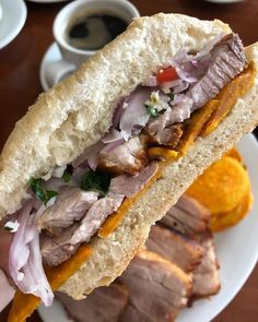 a sandwich with meat and vegetables on a plate