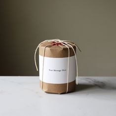 a brown paper bag tied with twine on top of a white counter