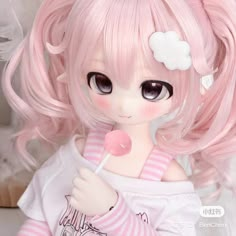 a doll with pink hair holding a lollipop in her hand and looking at the camera