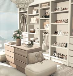 a white closet with shoes and bags on the shelves next to a footstool