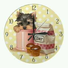 a clock with a small dog sitting in a pink cup next to a bag of donuts