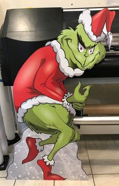 a cardboard cut out of the grinch from how the grinch stole christmas cheer