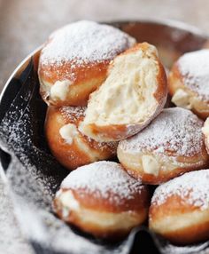 powdered sugar covered donuts in a metal bowl