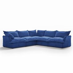 a blue sectional couch with pillows on it's back and arms, facing the camera