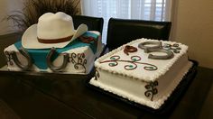 two cakes decorated with cowboy hats and horseshoes are sitting on a table in front of a window