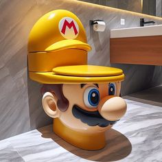 a toilet that has a mario bros character on it's head in the bathroom