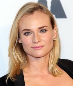 a blonde woman with blue eyes and long hair wearing a black top is looking at the camera