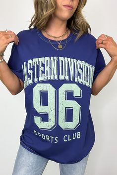 Details: Score big style points with this oversized tee from Eastern Division Sports Club! Show off your love for sports while keeping comfortable in this short-sleeved graphic tee. Perfect for game day or hanging out with friends, this tee is sure to become a favorite addition to your wardrobe. Get yours now! - "Eastern Division Sports Club" graphic - Short sleeves Content: 100% COTTON Size + Fit Model is 5'4" and wearing a SMMeasurements from a size SM are approx - Full length: 29" - Chest: 42 Trendy Oversized Sports Tops, Blue Sports T-shirt With Text Print, Blue T-shirt With Letter Print For Workout, Blue Letter Print T-shirt For Workout, Blue Workout T-shirt With Letter Print, Sporty Oversized Tops With Letter Print, Blue Sportswear T-shirt With Letter Print, Blue Graphic Workout T-shirt, Blue Graphic Print Workout T-shirt